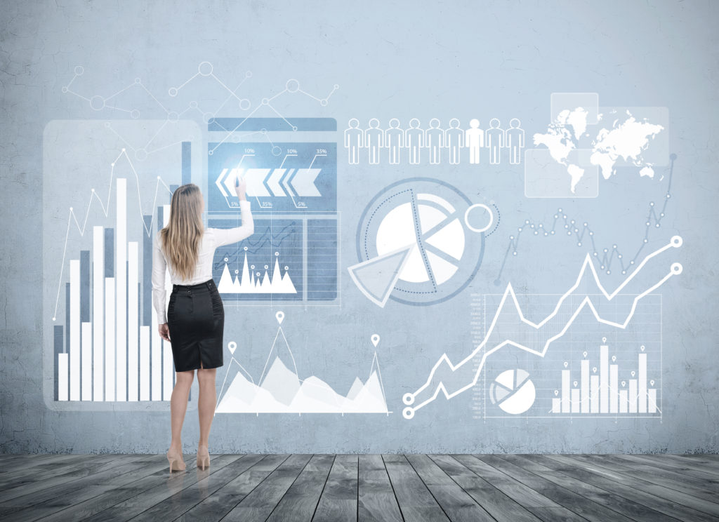 Rear view of young businesswoman wearing a suit standing in a room with a wooden floor and a concrete wall and interacing with HUD Toned image double exposure Elements of this image furnished by NASA