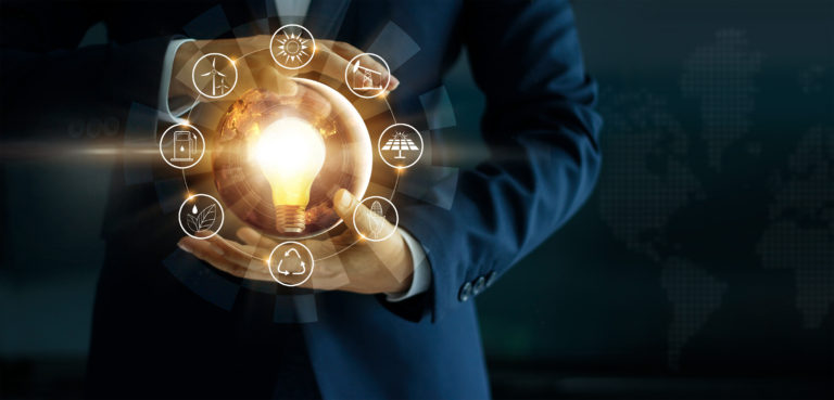 Businessman' s hand holding glowing light bulb with energy sources icon. Campaigning for ecological friendly and sustainable environment. Earth day. Energy saving concept, Elements of this image furnished by NASA