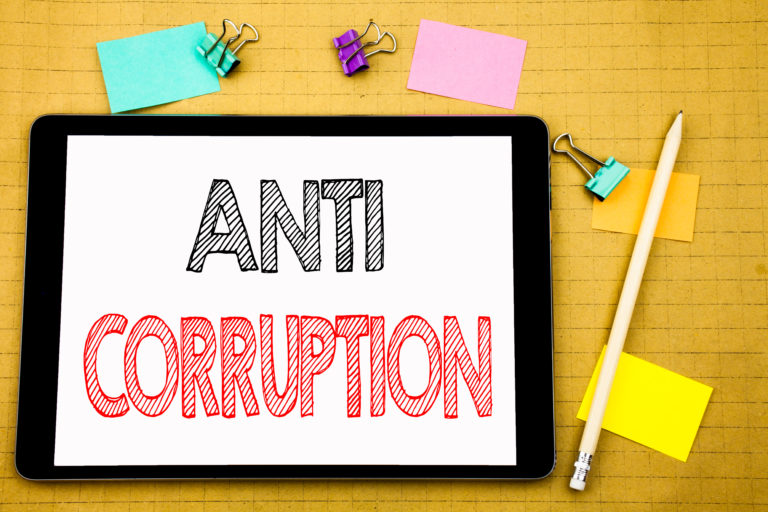 Word, writing Anti Corruption. Business concept for Bribery Corrupt Text Written on laptop, wooden background with sticky note and pen
